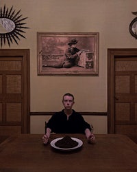 a man sitting at a table with a plate in front of him