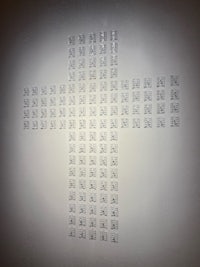 a cross made of small squares on a wall